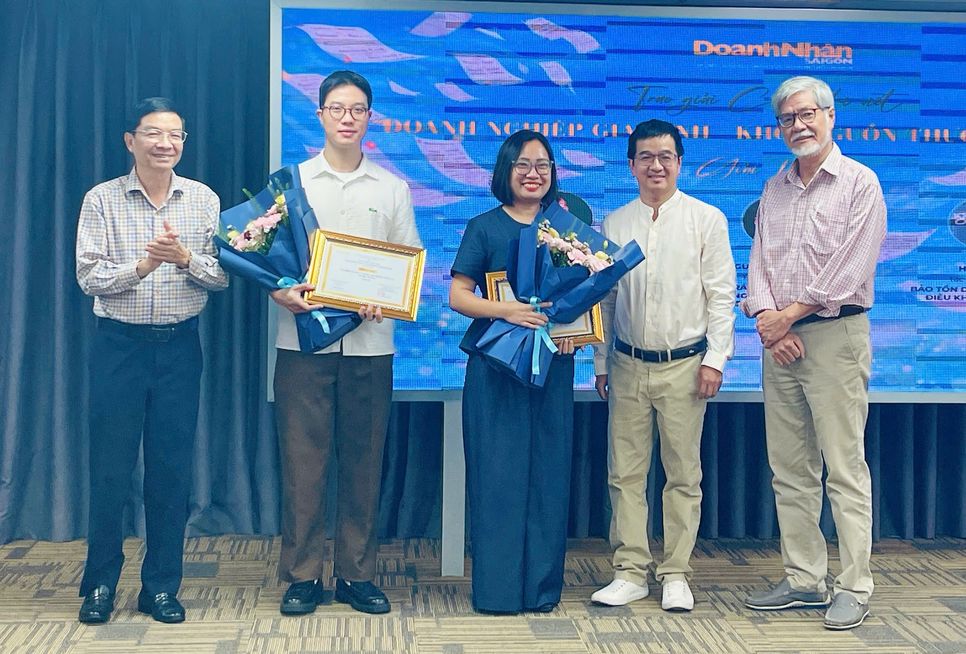 Nhà báo Ngô Xuân Lộc - Phó Tổng biên tập Tạp chí Doanh Nhân Sài Gòn (ngoài cùng bên trái) và nhà báo Nguyễn Trọng Chức - Trưởng ban Giám khảo (ngoài cùng bên phải) và ông Hứa Tấn Vinh - CEO Công ty Thái Mậu (Đông Nguyên) trao chứng nhận và hoa cho các tác giả đạt Giải Ba