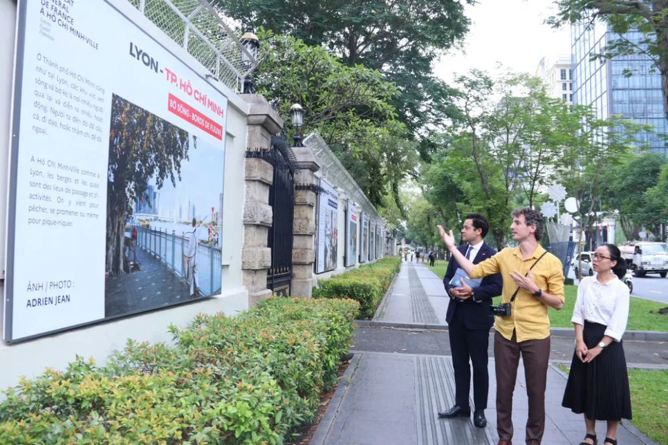 Nhiếp ảnh gia Adrien Jean (áo vàng) giới thiệu các tác phẩm. Ảnh: ĐỖ VĂN