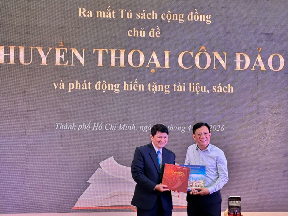 Đồng chí Nguyễn Ngọc Hồi đón nhận sách tặng từ Đại tá - NSNA Đoàn Hoài Trung. Ảnh: HỒ SƠN