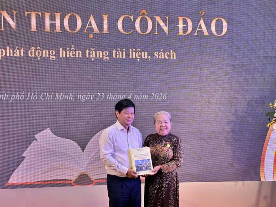 Nhà báo Trần Trọng Dũng, Phó Chủ tịch Hội Nhà báo Việt Nam, đón nhận sách tặng từ đồng chí Hoàng Thị Khánh, Chủ tịch Hội Chiến sĩ cách mạng bị địch bắt tù đày TPHCM. Ảnh: HỒ SƠN