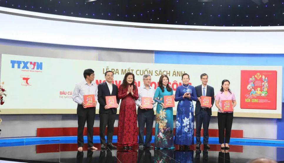 Ban tổ chức trao tặng cuốn sách đến các đại biểu dự buổi lễ. Ảnh: HOA NGUYỄN