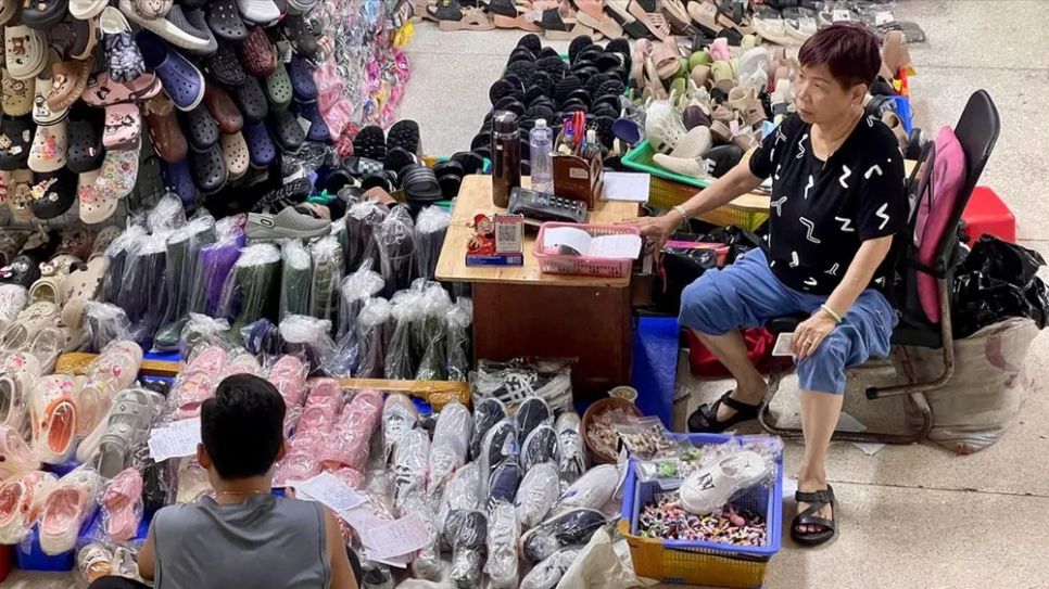 Tiểu thương chợ Bình Tây (TPHCM) ghi chép sổ sách tại quầy kinh doanh. ẢNH: HOÀNG HÙNG