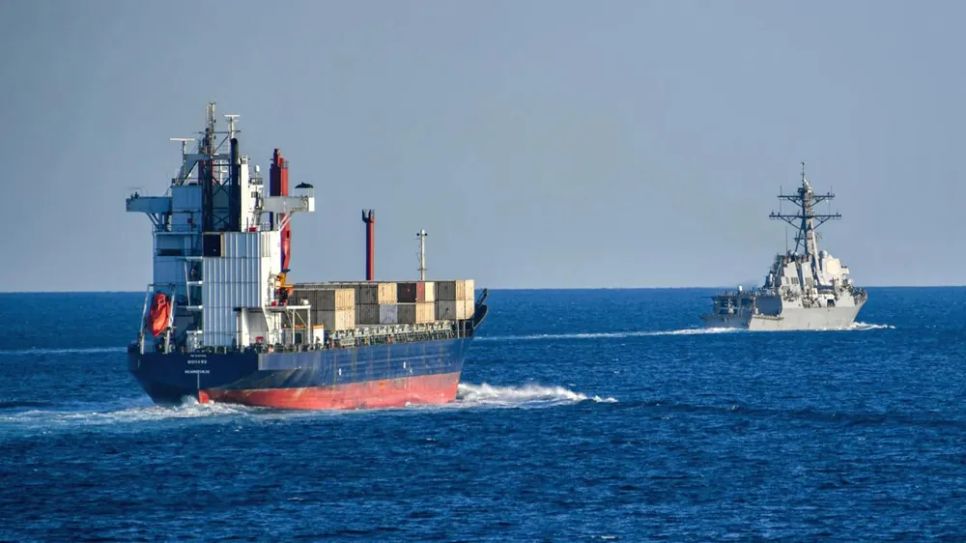 Tàu chiến Mỹ hộ tống một tàu chở hàng qua eo biển Hormuz. Ảnh: US NAVY
