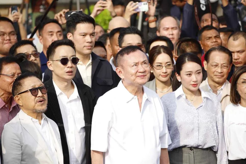 Ông Thaksin đứng im lặng trong khi quốc ca vang lên. Ảnh: BANGKOK POST