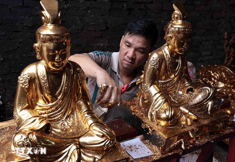 Tượng Phật được thếp vàng qua bàn tay khéo léo của người thợ Sơn Đồng. (Ảnh: Trần Việt/TTXVN)