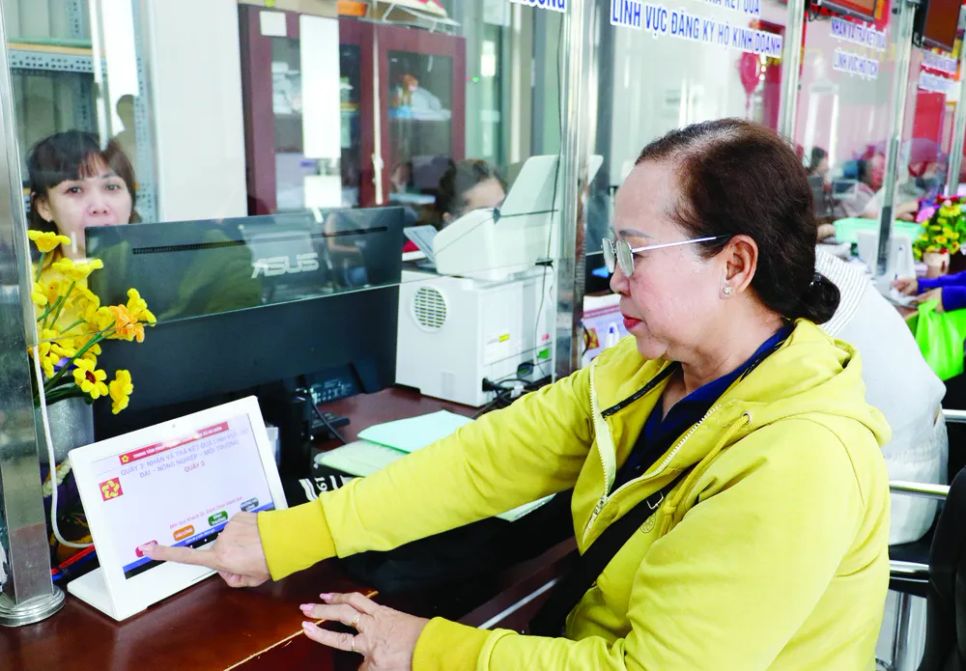 Người dân đánh giá sự hài lòng với sự phục vụ của công chức Trung tâm Phục vụ hành chính công xã Bà Điểm. Ảnh: Ngô Bình
