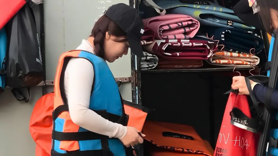 Du khách mặc áo phao và nghe hướng dẫn an toàn trước khi trải nghiệm chèo SUP