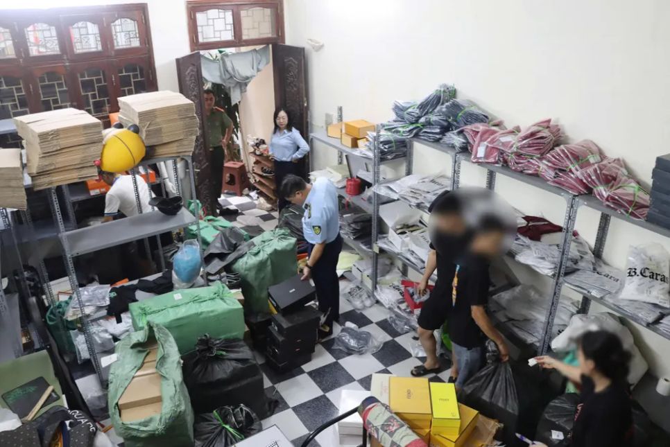 Lực lượng chức năng kiểm tra nơi tích chứa và kinh doanh các sản phẩm nghi giả mạo nhãn hiệu. Ảnh: BẢO TRUNG