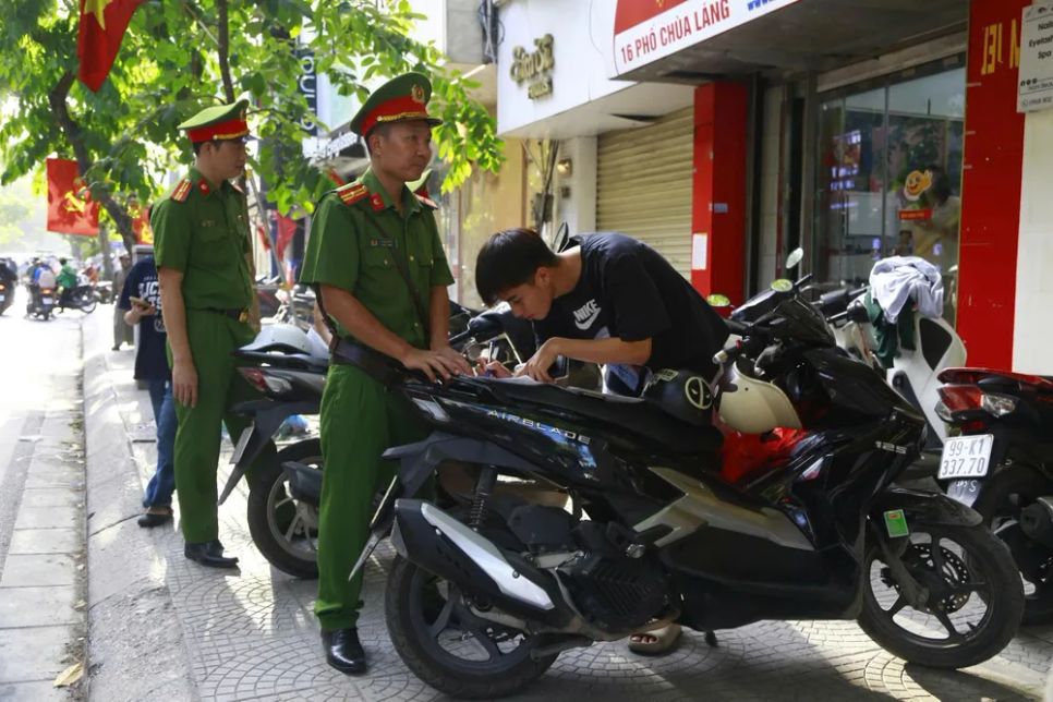 Lực lượng công an phường Láng tuần tra và xử phạt người vi phạm, lấn chiếm vỉa hè tại phố Chùa Láng, ngày 15-5. Ảnh: HÀ NGUYỄN