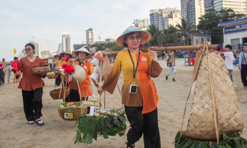 Hơn 70 gánh hàng rong diễu hành trên bãi biển Mỹ Khê trong “Gánh vị Đà Nẵng”. Các gánh hàng mang theo nhiều món ăn đặc trưng của miền Trung