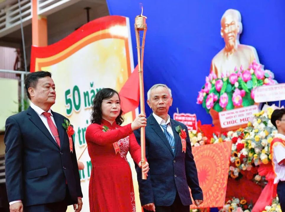 Cô Bùi Thị Kim Tuyến, Bí thư Chi bộ, Hiệu trưởng Trường THPT Nguyễn Trung Trực, cùng các thầy cô nguyên hiệu trưởng thực hiện nghi thức rước đuốc truyền thống