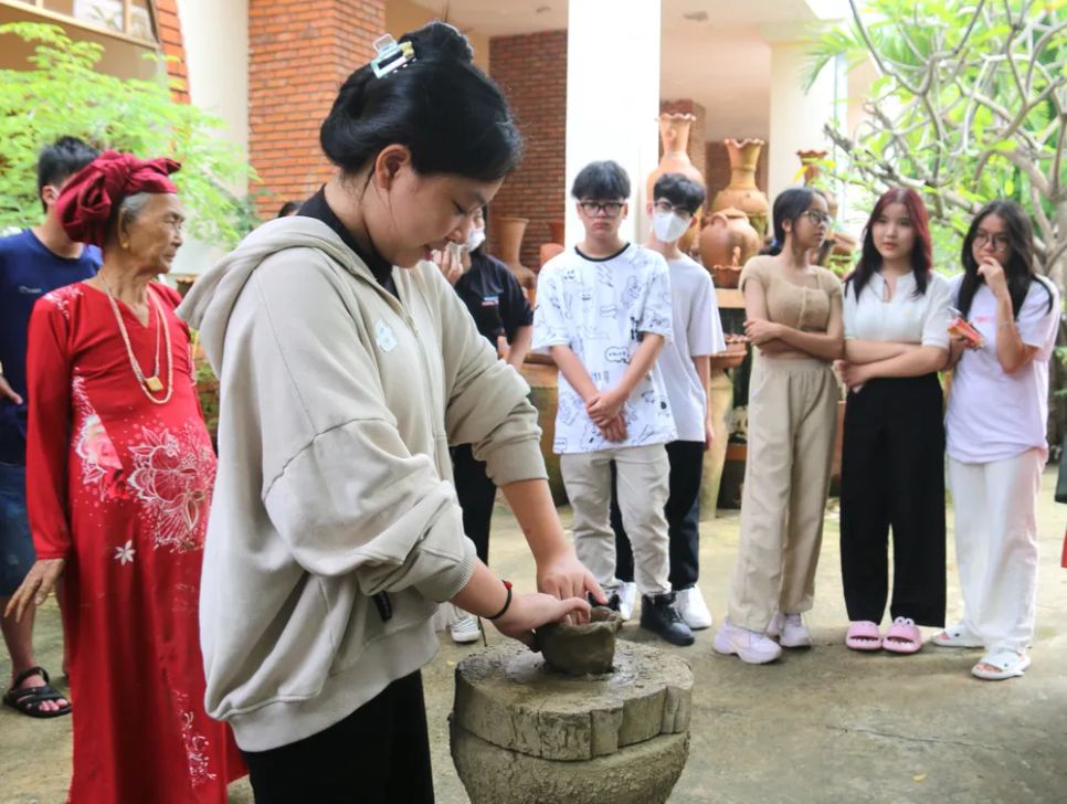 Vào các dịp hè, giới trẻ đến tham quan, trải nghiệm nghề gốm Chăm. Ảnh: TIẾN THẮNG