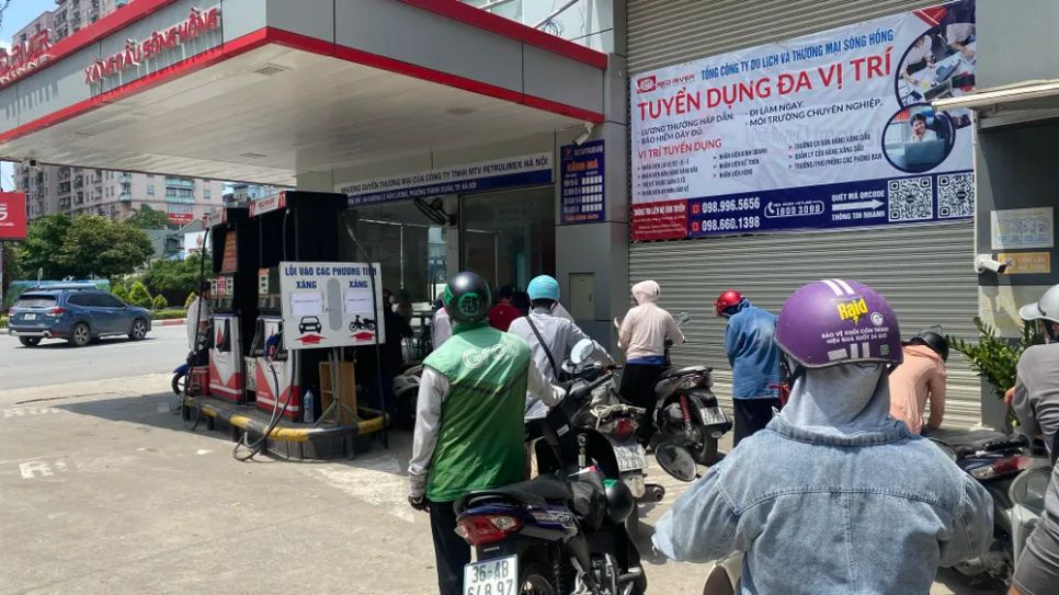 Người dân Hà Nội chờ đổ xăng E10 trên đường Lê Văn Lương trưa 28-5. Ảnh: PHÚC HẬU