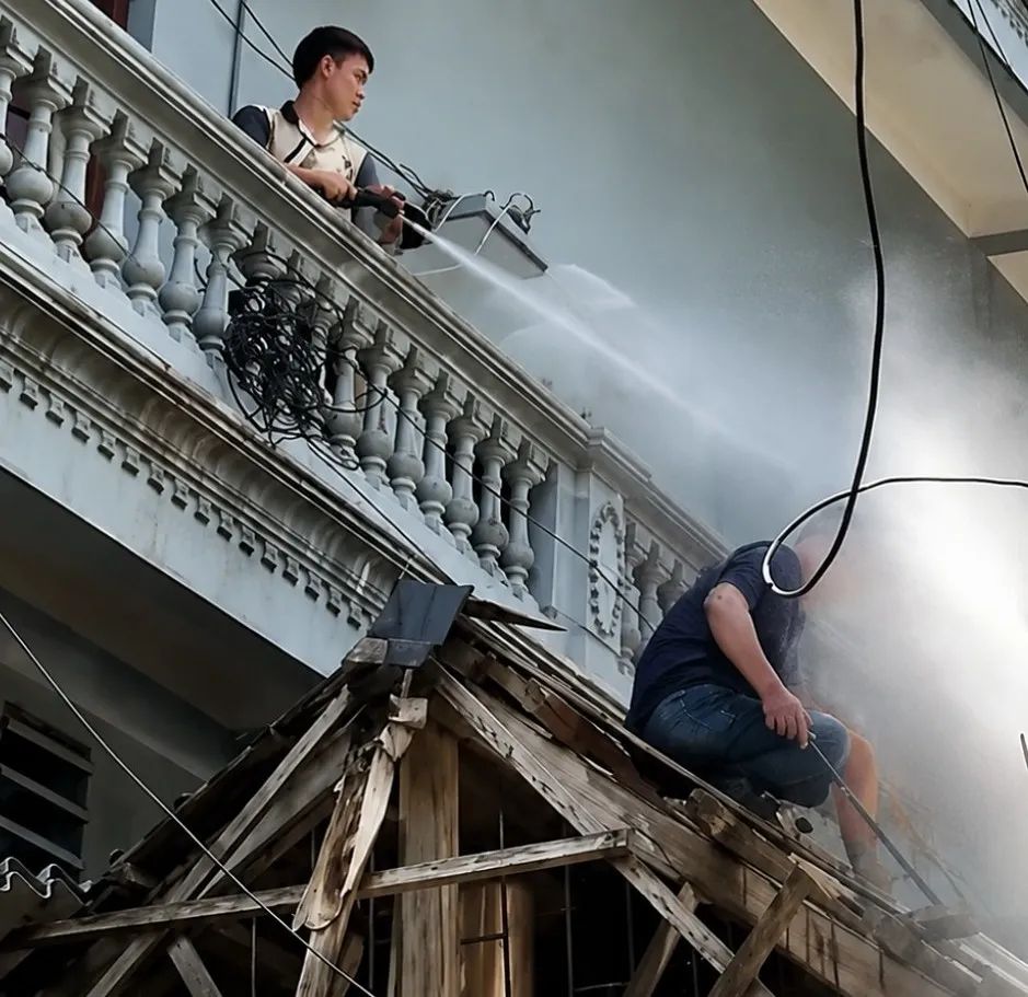 Hình ảnh người đàn ông cầm vòi nước xịt liên tiếp về phía người thợ xây. Ảnh cắt từ clip