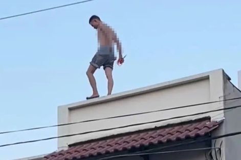 Thanh niên nghi ngáo đá leo lên mái nhà đập phá 